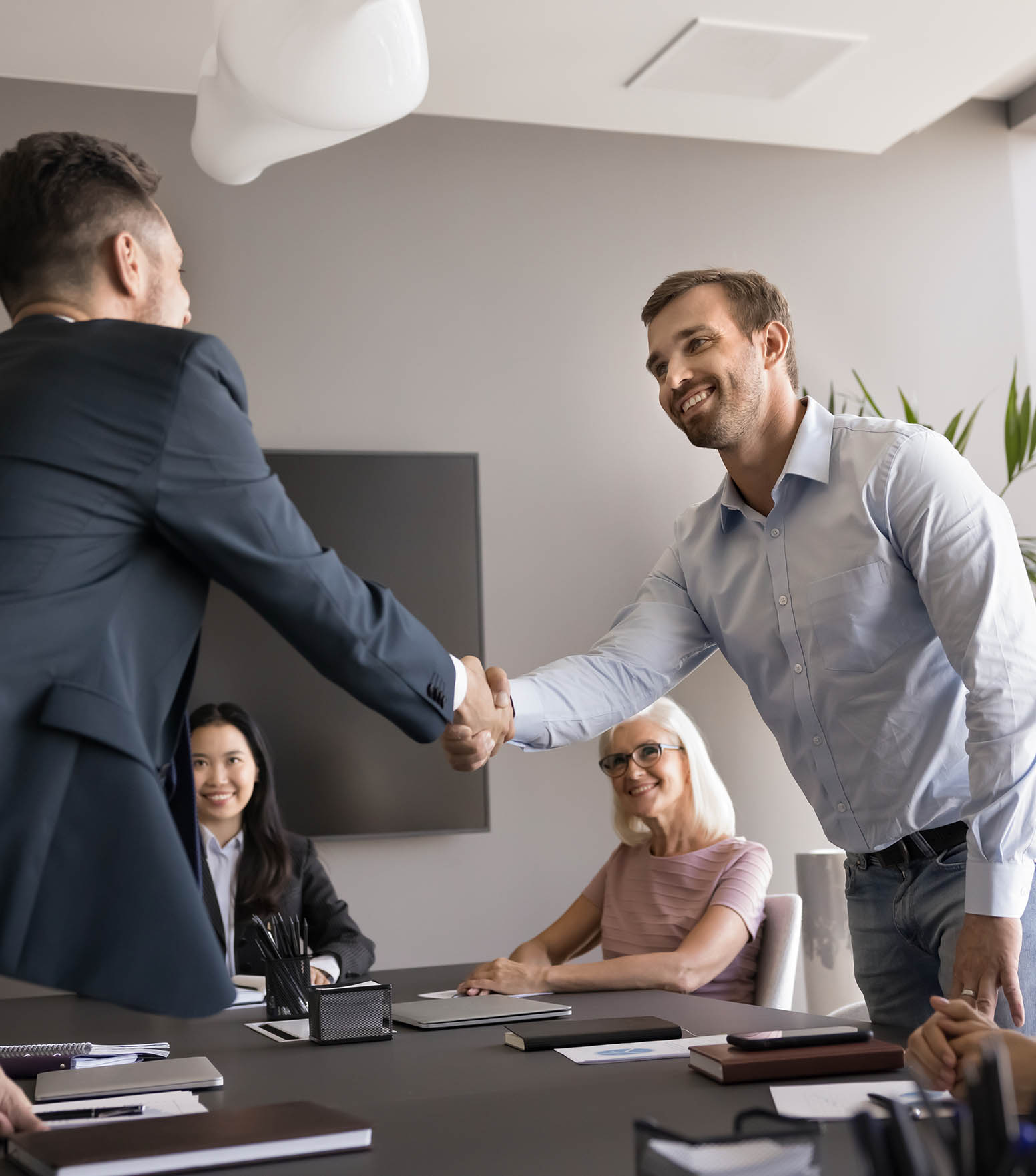 Two smiling male colleagues shake hands, closing profitable commercial deal