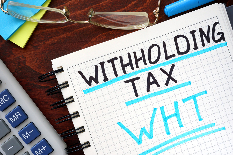 Whithholding tax WHT concept  written in a notebook on a wooden table.